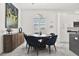 Dining area features round table with blue chairs, unique light fixture, and modern serving buffet at 5006 W Idaho St, Tampa, FL 33616