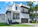 Contemporary home with clean lines, multi-level balconies, an attached garage, and lush landscaping at 5006 W Idaho St, Tampa, FL 33616