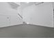View of the empty, spacious garage with epoxy floors and white walls and ceiling at 5006 W Idaho St, Tampa, FL 33616