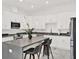Bright kitchen featuring white cabinets, marble floors, gray counters, and a spacious center island with bar seating at 5006 W Idaho St, Tampa, FL 33616