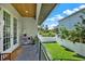 Back porch features a hanging chair, brick floor, wood ceiling, and view of the fenced backyard at 5006 W Idaho St, Tampa, FL 33616