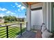 Front porch features brick floor, black railing and a wood bench with pillows and a view of the street at 5006 W Idaho St, Tampa, FL 33616