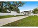 Backyard with driveway, covered parking, storage shed, privacy fence, and a well maintained lawn at 5055 9Th St, Zephyrhills, FL 33542