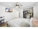 Bedroom featuring ceiling fan, tv, organized closet with custom shelves, and wood-look flooring at 5055 9Th St, Zephyrhills, FL 33542