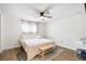 Bedroom with neutral tones, ceiling fan, wood-look flooring, and window providing natural light at 5055 9Th St, Zephyrhills, FL 33542