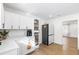 Bright kitchen featuring white cabinets, subway tile backsplash, stainless steel appliances, and wood-look flooring at 5055 9Th St, Zephyrhills, FL 33542
