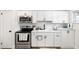Bright kitchen featuring white cabinets, stainless steel appliances, and tile backsplash at 5055 9Th St, Zephyrhills, FL 33542