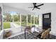 Bright, enclosed porch features a glass dining table, wicker chairs, and tiled floors at 5055 9Th St, Zephyrhills, FL 33542