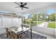Bright, enclosed porch features a glass dining table, wicker chairs, and tiled floors at 5055 9Th St, Zephyrhills, FL 33542