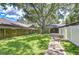 Spacious backyard with green grass, large trees, and stone walkway at 512 Pinewalk Dr, Brandon, FL 33510