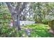 Well-maintained backyard with a white fence, lush greenery, and mature trees providing ample shade at 512 Pinewalk Dr, Brandon, FL 33510