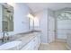 Bathroom with double vanity, granite countertop, modern fixtures, and a large arched window at 512 Pinewalk Dr, Brandon, FL 33510