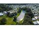 Aerial view features a scenic community lake surrounded by lush trees and well-maintained lawns amidst a residential area at 5706 Benton St, Zephyrhills, FL 33542