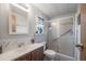 Bathroom with vanity, toilet, and frosted glass enclosed shower at 5706 Benton St, Zephyrhills, FL 33542