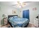 Cozy bedroom with ceiling fan, picture window with curtains, and plank flooring at 5706 Benton St, Zephyrhills, FL 33542