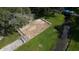An aerial shot of a bocce ball court surrounded by benches, a covered dock, and lush greenery in a park-like setting at 5706 Benton St, Zephyrhills, FL 33542
