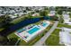 Aerial view features a fenced community pool and clubhouse area, complete with ample seating and well-maintained landscaping at 5706 Benton St, Zephyrhills, FL 33542