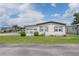 Charming single-story home featuring vinyl siding, green lawn, and a clean, well-maintained front yard in a friendly neighborhood at 5706 Benton St, Zephyrhills, FL 33542