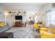 Open-concept living room with a large area rug, modern decor, and a view of the dining area, ideal for entertaining at 5706 Benton St, Zephyrhills, FL 33542