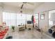 Bright sunroom features tile flooring, wicker furniture, and large windows with white curtains, creating a cozy and inviting space at 5706 Benton St, Zephyrhills, FL 33542
