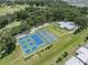 This bird's-eye view features the community's tennis courts and lush green surroundings at 5706 Benton St, Zephyrhills, FL 33542