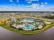 Aerial view showcasing community amenities; a luxurious pool area, clubhouse, and tennis courts against a picturesque backdrop at 6211 Sea Air Dr, Apollo Beach, FL 33572