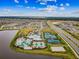Community aerial view of a pool and tennis courts with lush landscaping, nearby housing, and a scenic lake at 6211 Sea Air Dr, Apollo Beach, FL 33572
