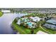 Scenic aerial view featuring community pool, clubhouse and sports courts nestled beside a picturesque lake at 6211 Sea Air Dr, Apollo Beach, FL 33572