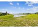 Scenic backyard view with a tranquil pond and lush green surroundings, offering a peaceful outdoor space at 6211 Sea Air Dr, Apollo Beach, FL 33572