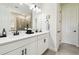 Bathroom featuring double sinks, white cabinetry, dark hardware and tile flooring at 6211 Sea Air Dr, Apollo Beach, FL 33572