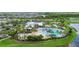 Aerial view of a community pool area with palms, a slide, clubhouse and beautiful landscaping at 6211 Sea Air Dr, Apollo Beach, FL 33572