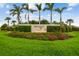 Beautifully landscaped community entrance sign with vibrant flowers, lush greenery, and palm trees at 6211 Sea Air Dr, Apollo Beach, FL 33572