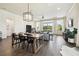 Open-concept dining area with wood table, black chairs, and a view of the backyard through large windows at 6211 Sea Air Dr, Apollo Beach, FL 33572