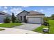 Charming single-story home with a stone facade, well-manicured lawn, and a paved driveway leading to a two-car garage at 6211 Sea Air Dr, Apollo Beach, FL 33572
