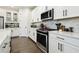 Modern kitchen with white cabinets, stainless steel appliances, and breakfast bar at 6211 Sea Air Dr, Apollo Beach, FL 33572