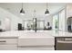 Close-up of the kitchen island with white countertop and a farmhouse sink with black faucet at 6211 Sea Air Dr, Apollo Beach, FL 33572
