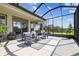 Well-lit, screened-in patio with modern seating and view of well-maintained lawn at 6211 Sea Air Dr, Apollo Beach, FL 33572