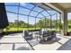 Relaxing screened patio with gray outdoor seating, view of the backyard, and blue sky at 6211 Sea Air Dr, Apollo Beach, FL 33572
