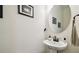 Stylish powder room features a pedestal sink, round mirror, and elegant fixtures at 6211 Sea Air Dr, Apollo Beach, FL 33572