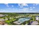 Community tennis courts surrounded by lush greenery and landscaping with a serene lake in the background at 6211 Sea Air Dr, Apollo Beach, FL 33572