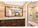 Bathroom featuring double sinks, granite counters and tiled walk-in shower at 6709 Peachtree Dr, Temple Terrace, FL 33617