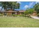 Beautiful single-story home with stone accents, manicured lawn, and established landscaping at 6709 Peachtree Dr, Temple Terrace, FL 33617