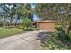 Exterior featuring a charming home with a two-car garage and a long driveway at 6709 Peachtree Dr, Temple Terrace, FL 33617