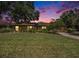 Charming single-story home with manicured lawn at dusk at 6709 Peachtree Dr, Temple Terrace, FL 33617