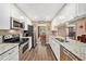 Well-lit kitchen featuring granite countertops, stainless appliances and wood flooring at 6709 Peachtree Dr, Temple Terrace, FL 33617