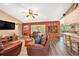 Cozy living room featuring leather seating, wood floors, and a ceiling fan at 6709 Peachtree Dr, Temple Terrace, FL 33617