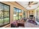 Bright sunroom with large windows offering a view of the landscaped yard at 6709 Peachtree Dr, Temple Terrace, FL 33617