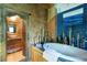 Bathroom featuring a large soaking tub, tiled walls, unique decor, and bamboo accents at 6924 Valrie Ln, Riverview, FL 33569