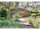A charming exterior view showcases a unique home design with a wood pathway and lush landscaping at 6924 Valrie Ln, Riverview, FL 33569