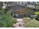 A charming exterior view showcases a unique home design with a wood pathway and lush landscaping at 6924 Valrie Ln, Riverview, FL 33569